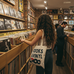 Girl browsing records in a store with a 'Books & Vinyl' tote bag. Eco-Friendly Shopping Bag, Gift for Book Lovers, Music Enthusiast, Reading Accessory, Perfect for Libraries, Schools